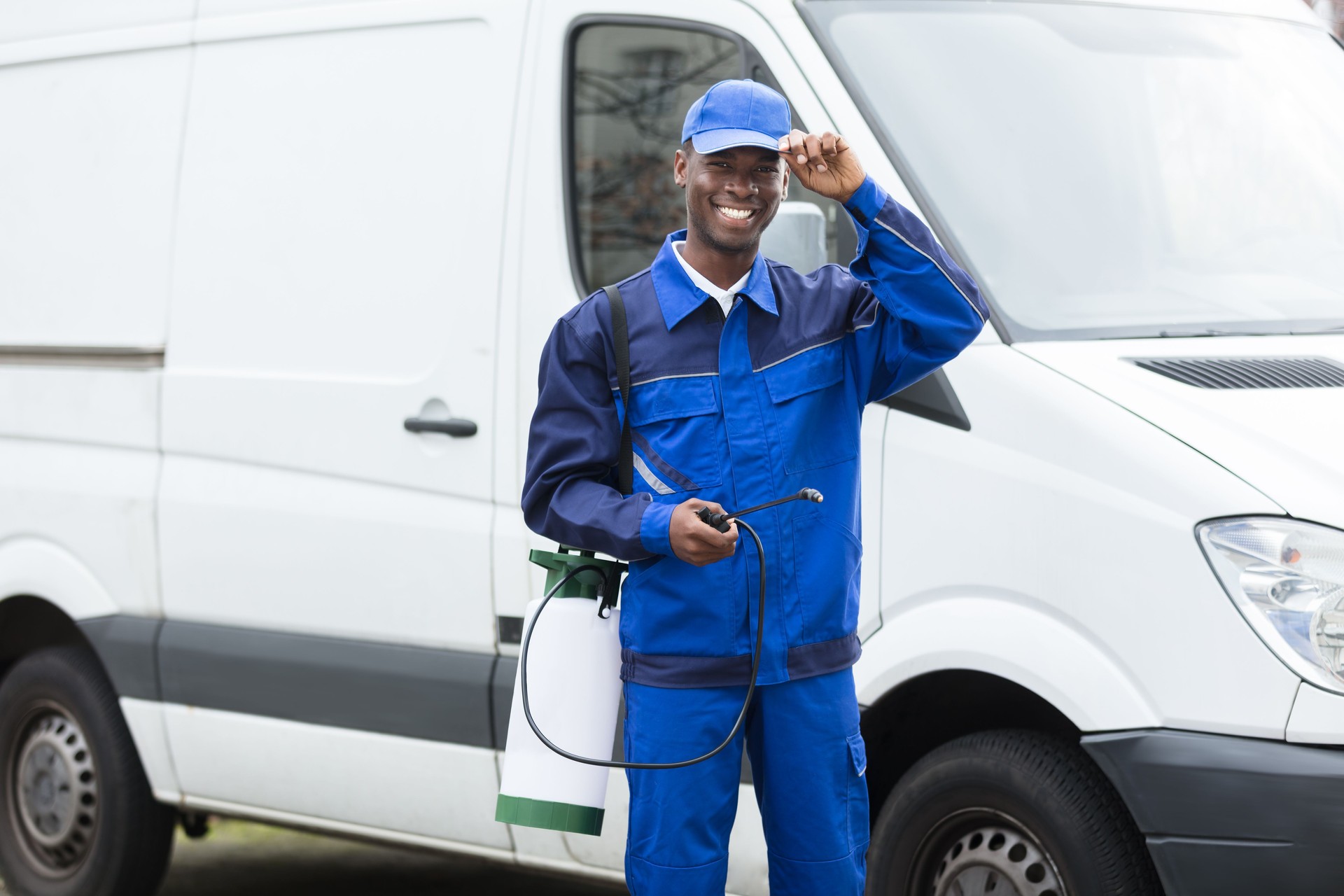 Jeune souriant travailleur masculin avec pulvérisateur de Pesticide